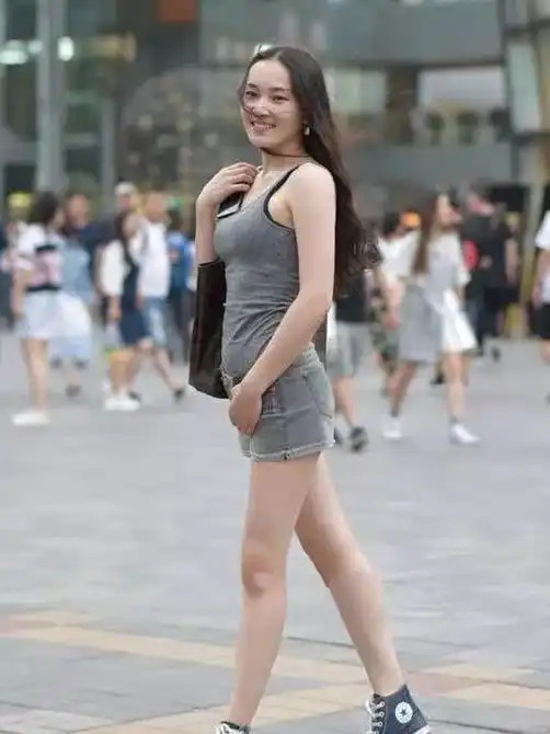  街拍笑容甜美的美女,一件灰色背心配牛仔热裤,时尚青春靓丽美