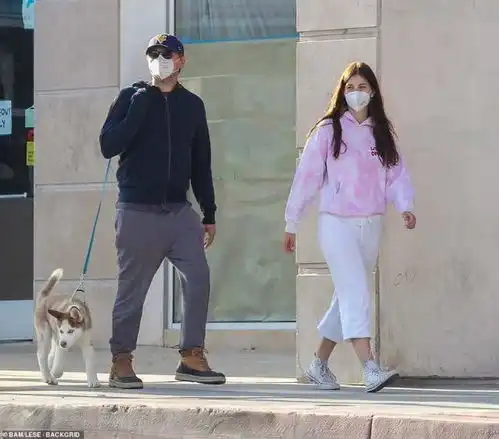  45岁小李子久违出街,戴口罩遛狗,22岁女友同行,穿白裤腿太粗