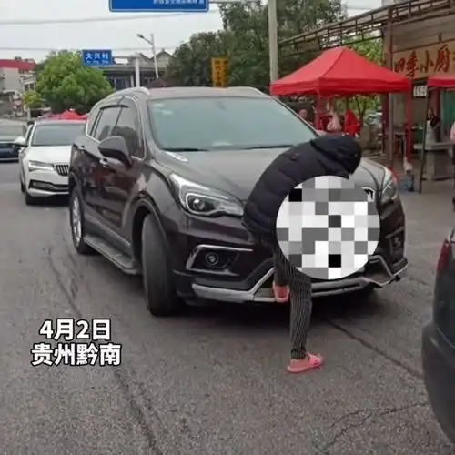  贵州女子拦车要钱,不给钱就踩车,上去一脚,踩掉挡板