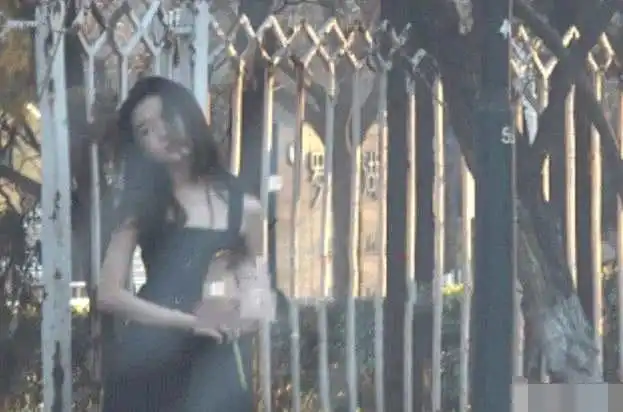  李嫣大冷天穿吊带装街头拍照撩发甩头画风显成熟
